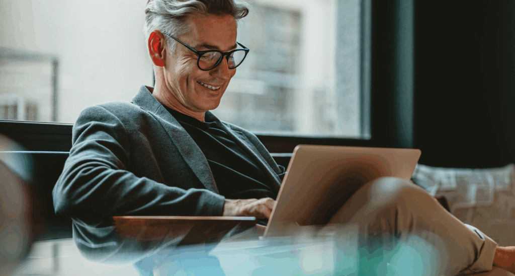 man at desk looking at laptop