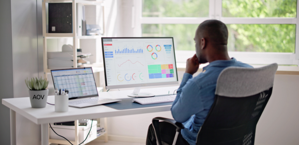 man at desk looking at statistics.  ROI and analytics